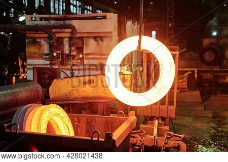 Group of workers in helmets melting metal in metal fabrication plant