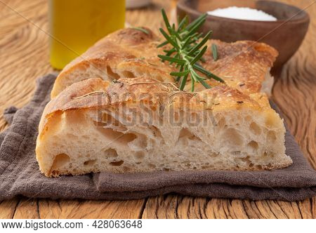 Home Made Focaccia With Salt, Olive Oil And Rosemary Over Wooden Table.