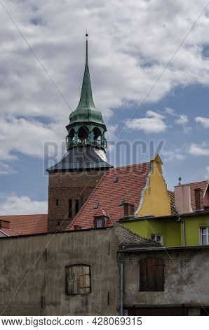 Cityscape - A Church Tower Against The Background Of Walls Of Old Town Houses
