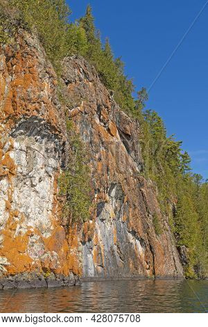 Orange Colored Cliffs High Above The Wilderness Waters On Ottertrack Lake In The Boundary Waters In 