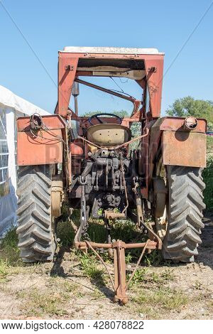 Vintage Tractor. Retro Agricultural Farm Vehicle. Rusty Red Vehicle With Towbar. Rear View Of Old Tr