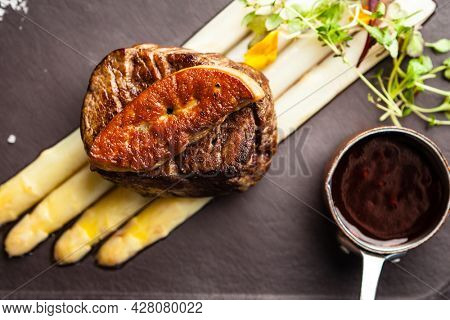 Tournedos Rossini. Foie gras, Black Angus beef tenderloin, white asparagus, red wine sauce. Delicious healthy traditional food closeup served for lunch in modern gourmet cuisine restaurant.