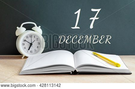 December 17. 17-th Day Of The Month, Calendar Date.a White Alarm Clock, An Open Notebook With Blank 