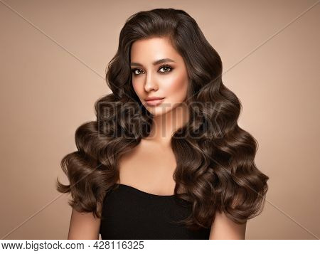 Brunette Girl With Perfect Makeup. Smiling Beautiful Model Woman With Long Curly Hairstyle. Care And