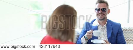 Businesswoman And Businessman Drink Coffee In Cafe
