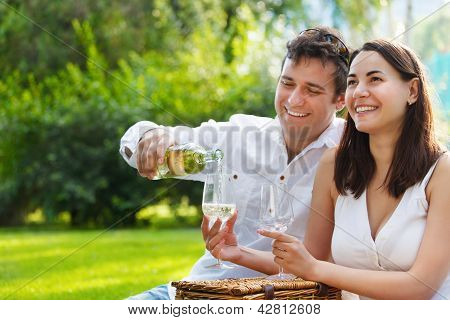 Unge lykkelige par nyder et glas hvidvin
