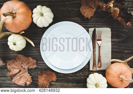 Holiday Place Setting With Plate, Napkin, Antlers And Silverware On A Thanksgiving Day Decorated Tab