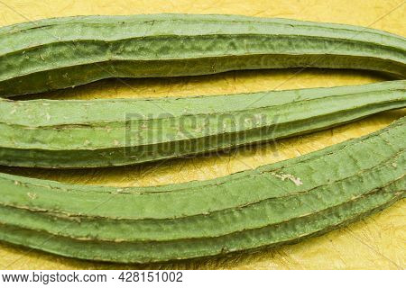 Ridge Gourd Vegetables Long And Thin On Yellow Background. Indian Or Southeastern Or Southasian Vege