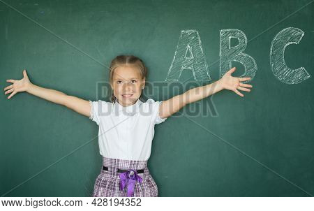 Portrait Of Caucasian Happy Child Girl With. School Chalkboard Or Blackboard Background. Education C