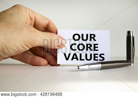 Our Core Values Symbol. White Paper With Words 'our Core Values' In Businessman Hand, Metallic Pen. 