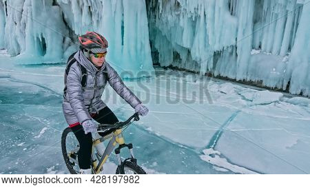 Woman Is Riding Bicycle Near The Ice Grotto. The Rock With Ice C