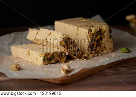 Organic Halva With Pistachios On A Wooden Surface. Traditional Middle Eastern Sweets. Jewish, turkis