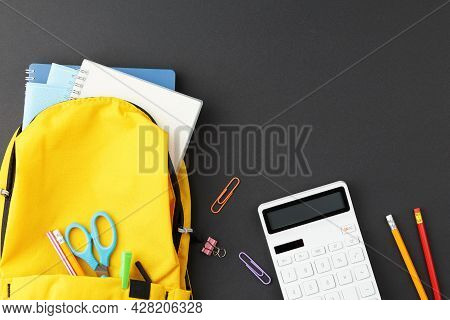 School Backpack With Calculator And Accessories On A Blackboard Background. Top View. Back To School