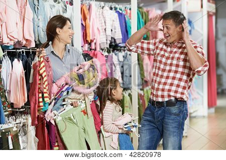 Aile alışveriş. Kadın ve kız kıyafetleri çok sürpriz baba adam ile alışveriş sırasında holding 