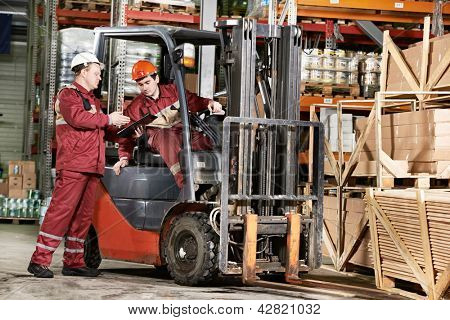 Junge Lagerarbeiter in Uniform vor Gabelstapler Stapler Radlader