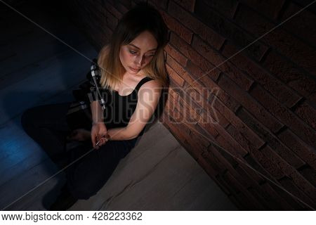 Overdosed Drug Addicted Woman Near Brick Wall. Space For Text