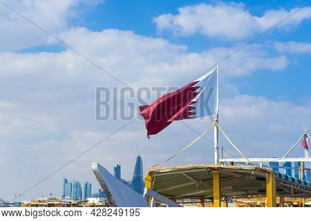 National Flag Of Qatar On A Flagpole In Front Of Blue Sky