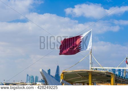 National Flag Of Qatar On A Flagpole In Front Of Blue Sky