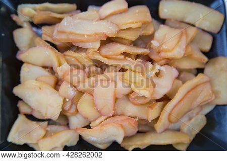 Octopus (latin Octopoda) Cut Into Pieces On A Black Rectangular Plate With A Wooden Table Background