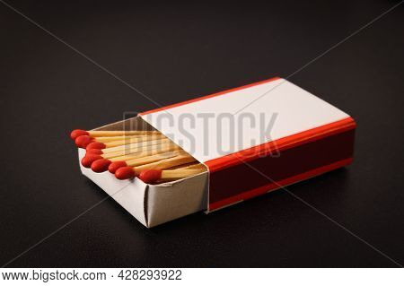 An Open Matchbox With A Blank White Label On A Black Table. Soft Focus.