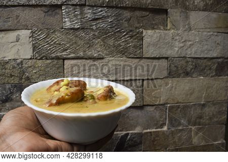 Female Hand Holding Kadhi Pakoda Or Kadhi Pakora An Indian And Pakistani Food Dish Recipe Item. Besa
