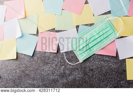 Above Many Blank Paper Stick Note List With The Face Mask Protective On Concrete Background, Quarant