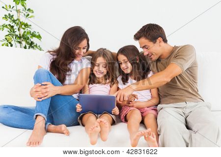 Usmívající se rodina pomocí digitální tablet na pohovce