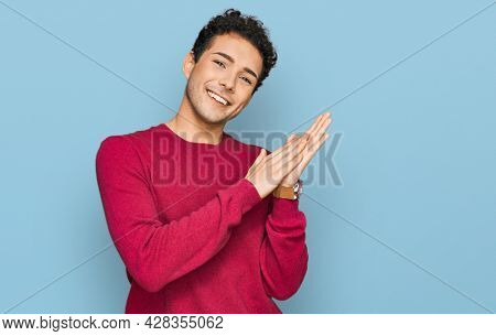 Young handsome man wearing casual clothes clapping and applauding happy and joyful, smiling proud hands together 