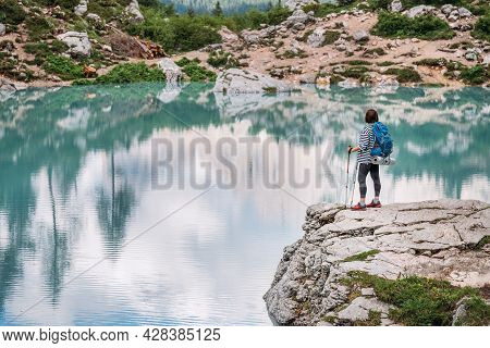 Backpacker Woman With Backpack And Trekking Poles Enjoying The Turquoise Lago Di Sorapiss 1925m Alti