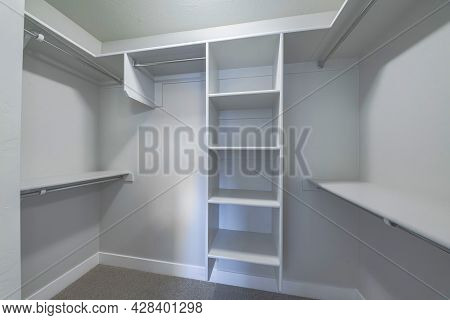 Empty Small Windowless Walk In Closet With Open Wardrobe