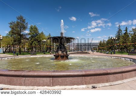 Russia, Irkutsk - May 27, 2021: Fountain And Hotel Angara In Tikhvinsky Or Kirov Square In Sunny Sum