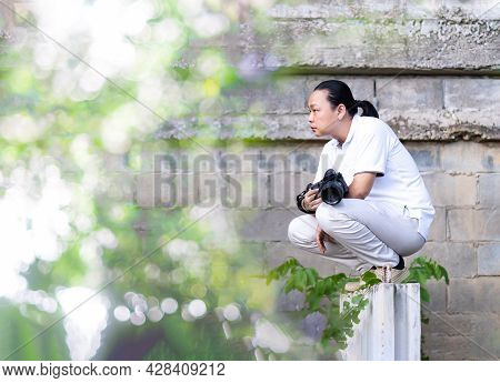 Asian Professional Cameraman Sits And Thinks About How To Create A Creativity Photo In The Construct