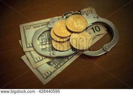 Golden Bitcoins Cryptocurrency With Handcuffs On Dollar Bills. Digital Crime, Arrest Or Hacking Conc
