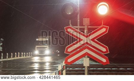 Train Crossing Gates Closed At Night. Train Grade Crossing With Blinking Or Flashing Lights While Tr