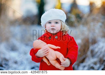Outdoor Winter Portrait Of Little Cute Toddler Girl In Red Coat And White Fashion Hat Barret. Health