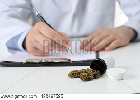 Doctor Writing At Table, Focus On Medical Hemp