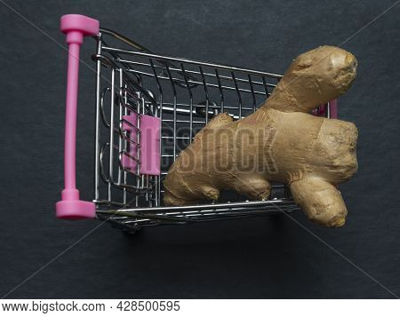 One Yellow Ginger Root Is In A Small Shopping Trolley. An Exotic Medicinal Plant In A Toy Metal Cart