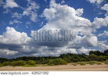 Cumulus Clouds Over Wild Sandy Coast Of The Baltic Sea In Vecaki, Latvia