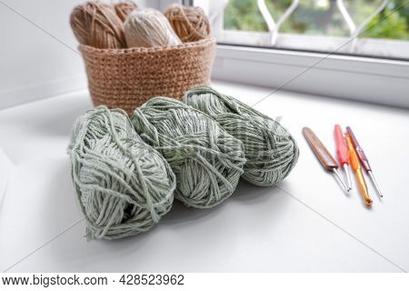 Yarn In A Knitted Basket On A White Background With Hooks. Yarn Of Different Colors. The Concept Of 