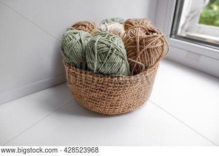 Yarn In A Knitted Basket On A White Background With Hooks. Yarn Of Different Colors. The Concept Of 