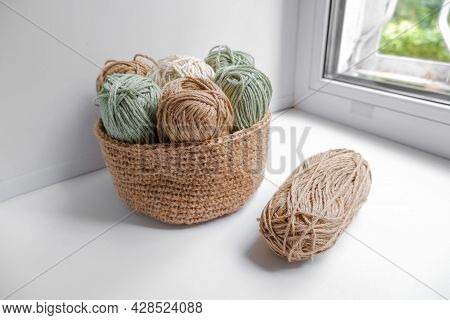 Yarn In A Knitted Basket On A White Background With Hooks. Yarn Of Different Colors. The Concept Of 