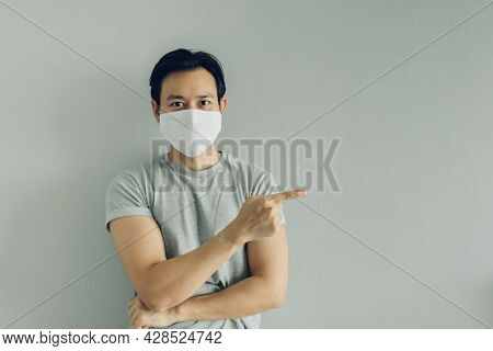 Normal Face Of Asian Man Wearing White Hygienic Mask In Grey T-thirt With Copy Space.