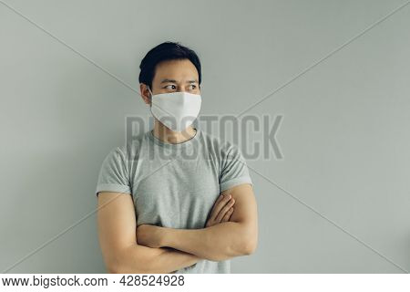 Normal Face Of Asian Man Wearing White Hygienic Mask In Grey T-thirt With Copy Space.