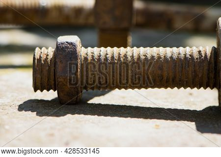 Old Rusty Bolt, Iron Rod With Screw Threads. Rusted Mechanical Components. Threaded Bolt And Nut. Di