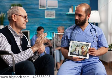 Pensioner Senior Male Greeting Remote Friends During Online Videocall Meeting Conference. Support As
