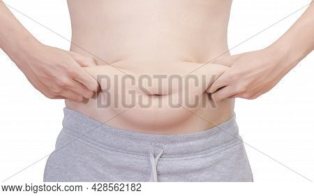 A Front View Of A White Man In Gray Pants Squeezing His Stomach With Both Hands To Reveal The Belly 