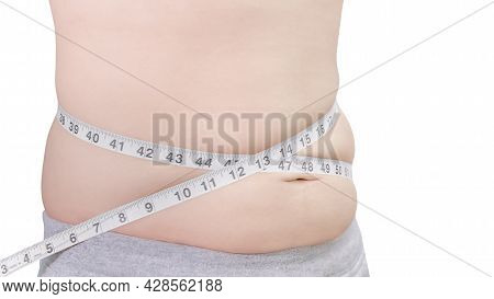 Side View Of A Fat White Man In Gray Pants Measuring His Waist With A Tape Measure Around His Body. 