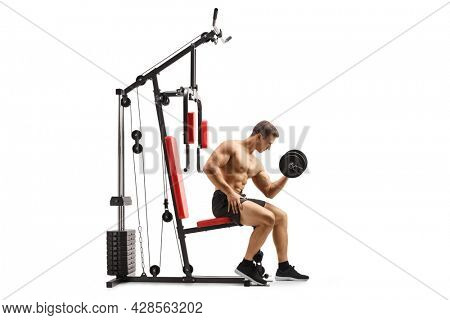 Shirtless musuclar man sitting on a fitness machine exercising with a dumbbell isolated on white background