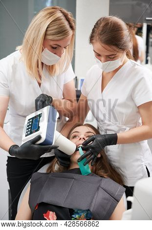 Doctors Using Portable Dental X-ray Machine While Examining Patient Teeth In Dental Office, Performi