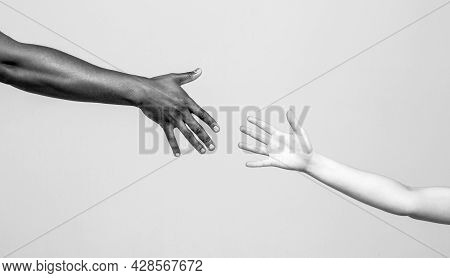 Black And White Human Hands. African And Caucasian Hands. Giving A Helping Hand To Another. Helping 